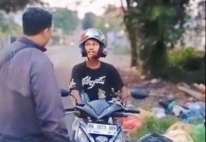 Petugas gabungan dari DLHK Kota Denpasar dan Pemerintah Desa Pemecutan Kaja saat melakukan pemeriksaan identitas warga yang kedapatan membuang sampah sembarangan di kawasan Jalan Gunung Himalaya, Pemecutan Kaja, Senin (10/3) malam.