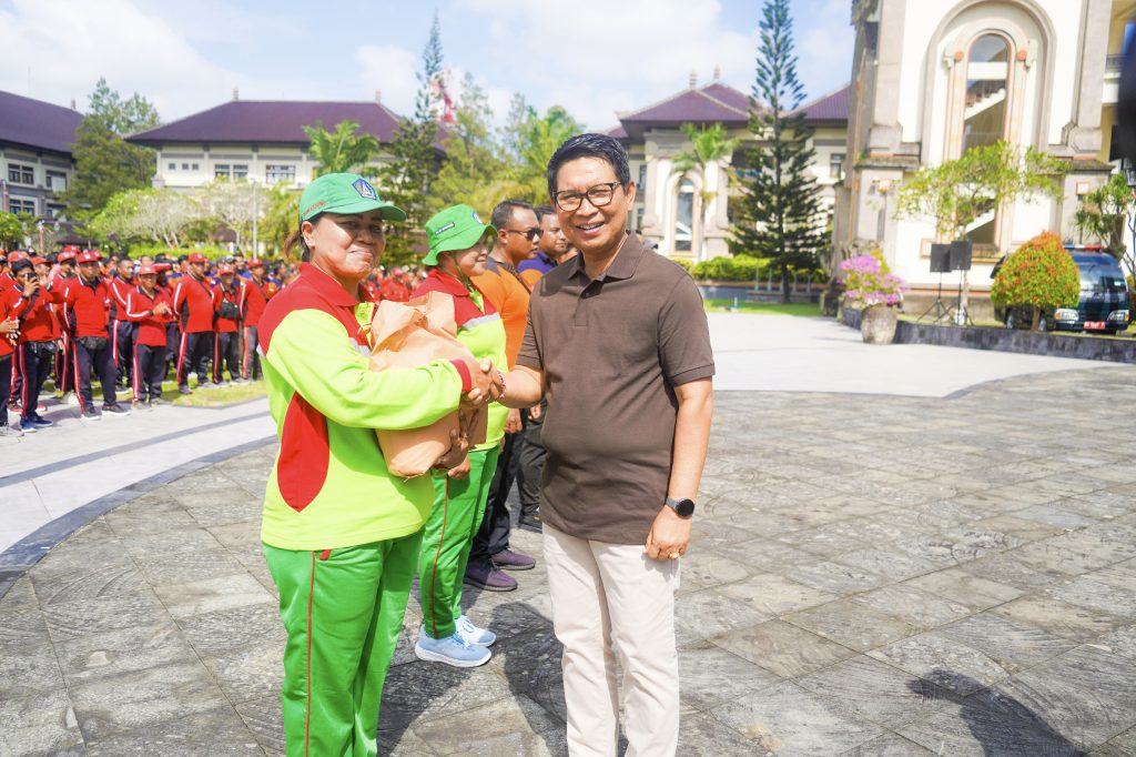 Bupati Wayan Adi Arnawa saat menyerahkan bantuan paket sembako bagi petugas lapangan di Lapangan Puspem Badung, Minggu (28/9)